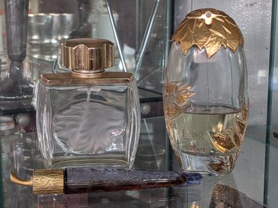 a glass display case with perfume bottles and a razor on it