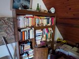 une bibliothèque remplie de livres, placée dans un coin de la pièce