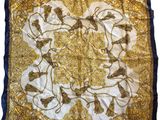 a gold and blue silk scarf with a picture of horses on it