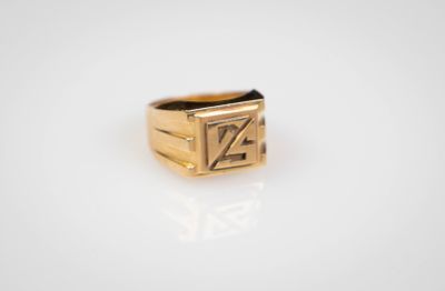 gros plan d'une bague en or sur une surface blanche