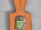 a leather keychain with a badge on it