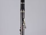 a black and silver clarinet sitting on top of a clear display case