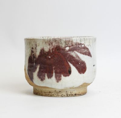 a close up of a white bowl with a red flower on it