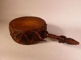 a small wooden drum with a feather on it