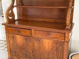 a wooden cabinet with a wooden top and a basket on the floor