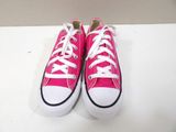 pink converses with white laces are on a white surface