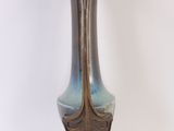 a blue and gold vase sitting on a white surface