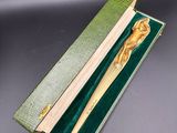un stylo en bois dans une boîte verte, muni d'un manche en bois