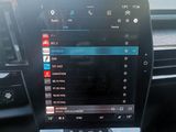 an image of a car dashboard with a touch screen and a steering wheel