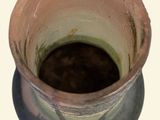 a small vase with a brown substance inside of it