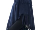 the woman is wearing a blue ponche with fringes on it