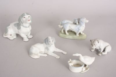five figurines of animals and a cup on a table