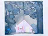 an open book with a picture of a house and a cat