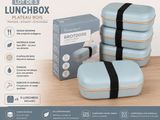 quatre boîtes à repas posées sur une table à côté d'un carton contenant de la nourriture