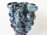 un vase bleu posé sur une surface blanche