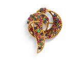 un gros plan sur une broche en or sertie de pierres multicolores