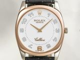 a close up of a wrist watch with a white dial and black leather strap