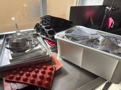 several trays of food are sitting on a counter in front of a window
