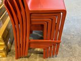 four red chairs stacked on top of each other in a store
