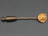 un gros plan d'un objet métallique sur lequel repose une pièce de monnaie