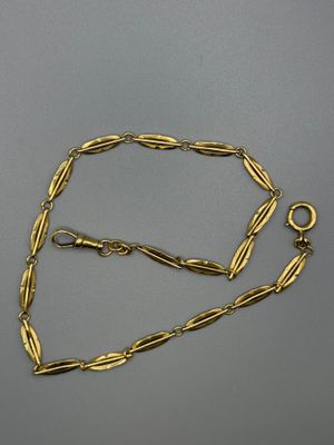 a close up of a gold necklace on a gray surface