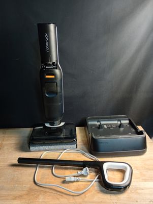 une photo d'un aspirateur sans fil et d'autres objets posés sur une table