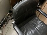 a black office chair sitting in front of a computer desk