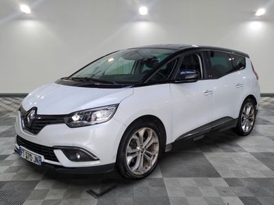 une voiture blanche garée sur un sol en damier dans un garage