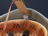 a close up of a metal colander with a strap on it
