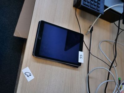 une tablette posée sur un bureau, avec un clavier et une souris