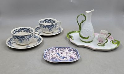 un pichet blanc et quatre tasses et soucoupes bleues et blanches posés sur un plateau