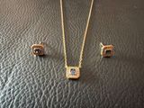 a gold necklace and earrings set with a blue stone