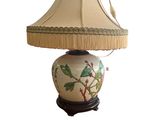 a lamp that has a bird on it on a table