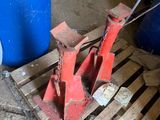 a red object on a pallet next to a blue barrel