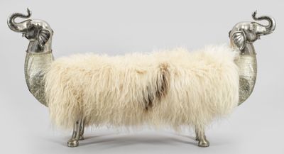 un mouton assis sur un banc en métal