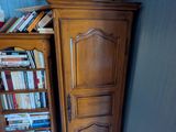 une armoire surmontée de livres, placée dans un coin de la pièce