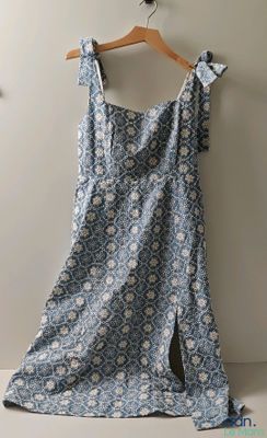 une robe bleue et blanche suspendue à un cintre