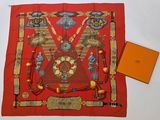 an image of a red scarf with a design on it and an orange box