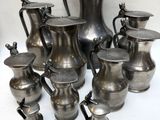 de nombreux vases en argent posés sur une table blanche