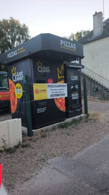 un homme qui roule à vélo dans la rue, devant un Pizza Hut