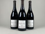 trois bouteilles de vin sont alignées sur une table