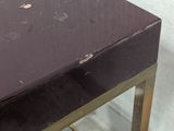 a table with a black top and gold legs