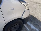 a white car that has been damaged and is parked in a parking lot