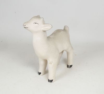 a small toy sheep that is standing on a white surface