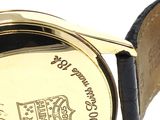a close up of a gold watch with a leather band