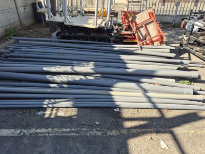 a pile of steel pipes sitting in a parking lot