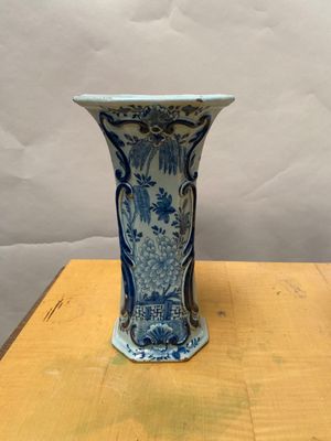 a blue and white vase sitting on top of a wooden table
