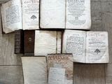 Plusieurs vieux livres sont empilés les uns sur les autres sur un plancher en bois.