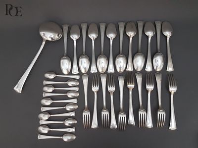 de nombreuses fourchettes et cuillères disposées sur la table