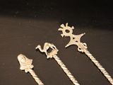 several silver metal items on a black surface with a black background